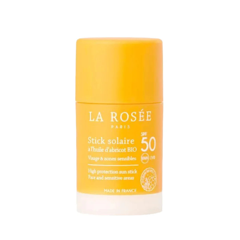 Gros plan du stick solaire SPF 50+ La Rosée en tube orange, affichant la marque, label fabriqué en F