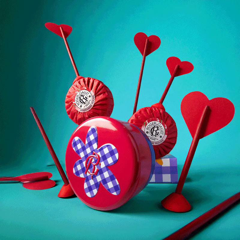 Parfums Roger & Gallet présentés de manière ludique avec fléchettes en forme de cœur et pommes rouge