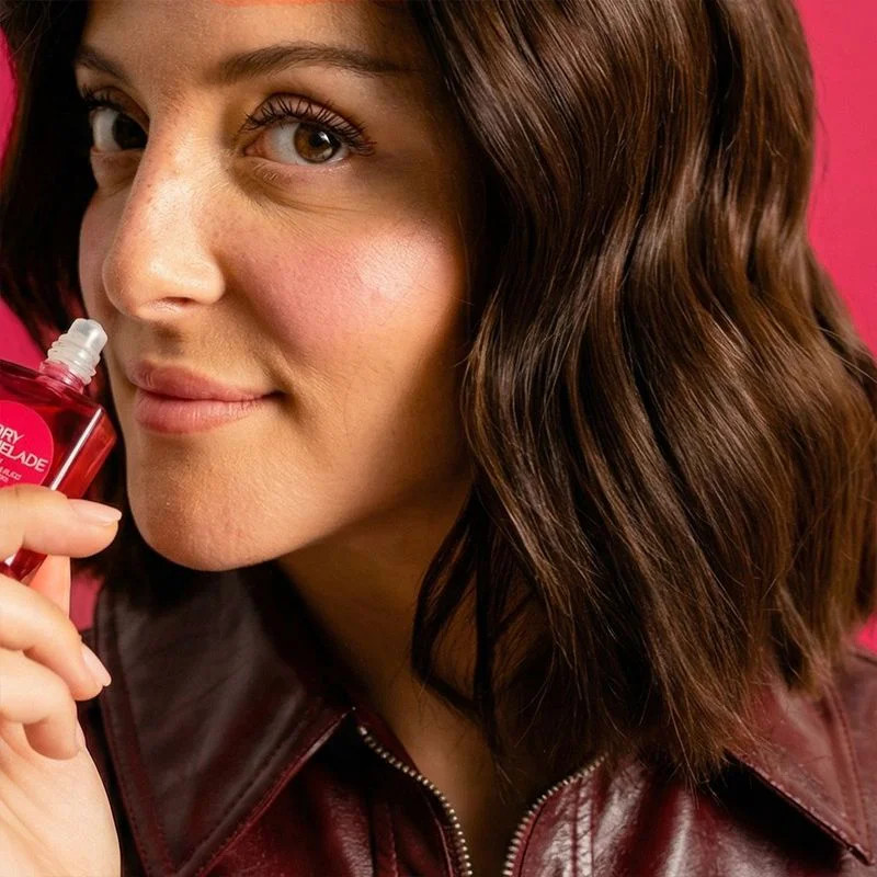 Femme appliquant le Roll-On Cherry Marmelade de Roger & Gallet sur les lèvres, portrait close-up ave